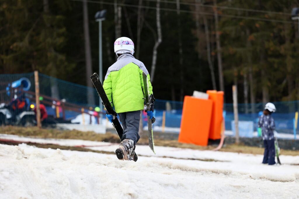 Dzieci uczące się narciarstwa biegowego na łatwych trasach – narty biegowe jako atrakcja zimowiska dla najmłodszych.